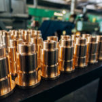 New brass threaded bushings on table in factory